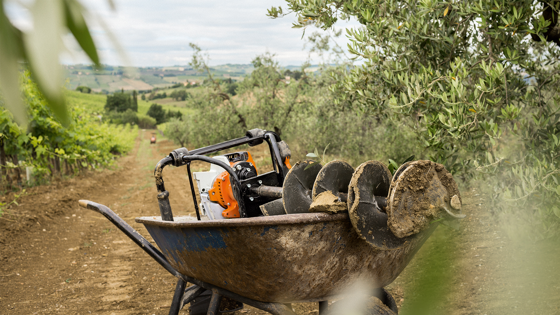 Perfurador de solo STIHL BT 131 num carrinho de mão no campo