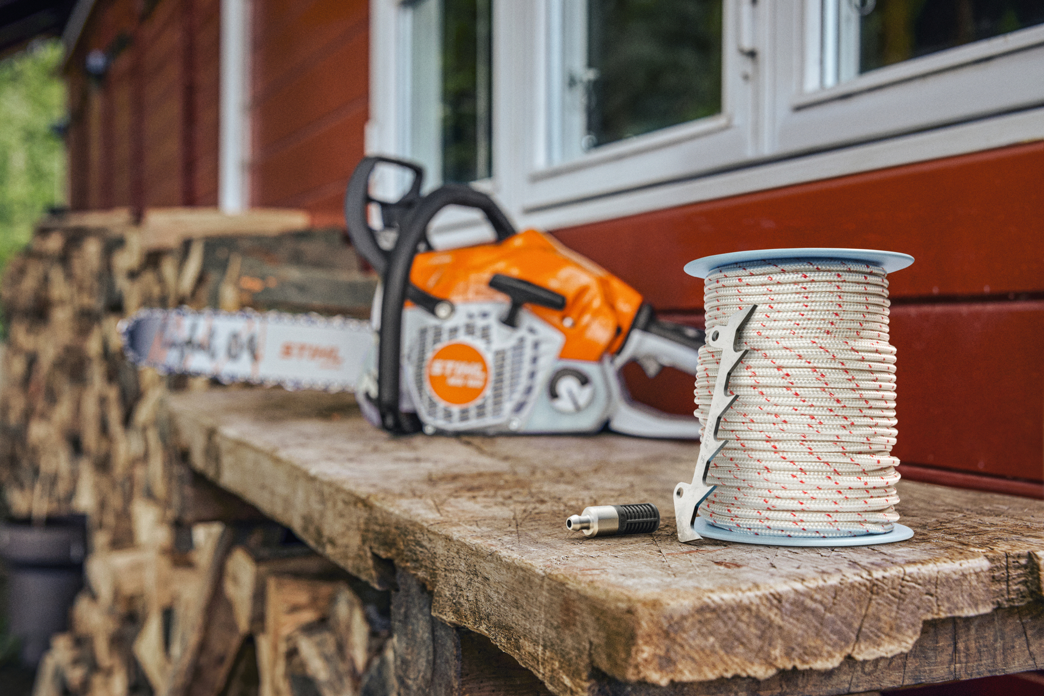 Motosierra STIHL en un banco de trabajo de madera con una polea de cuerda en primer plano