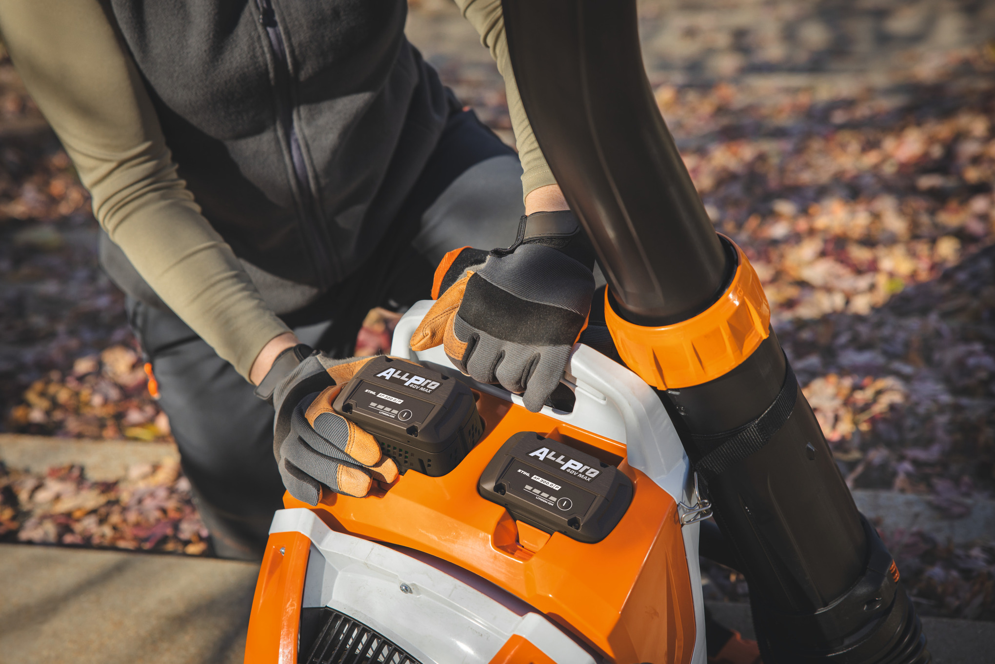 Un profesional Landschaftsgärtner establece el segundo STIHL-Akku AP 300.0 P en el STIHL-Akku-Rucksackgebläse