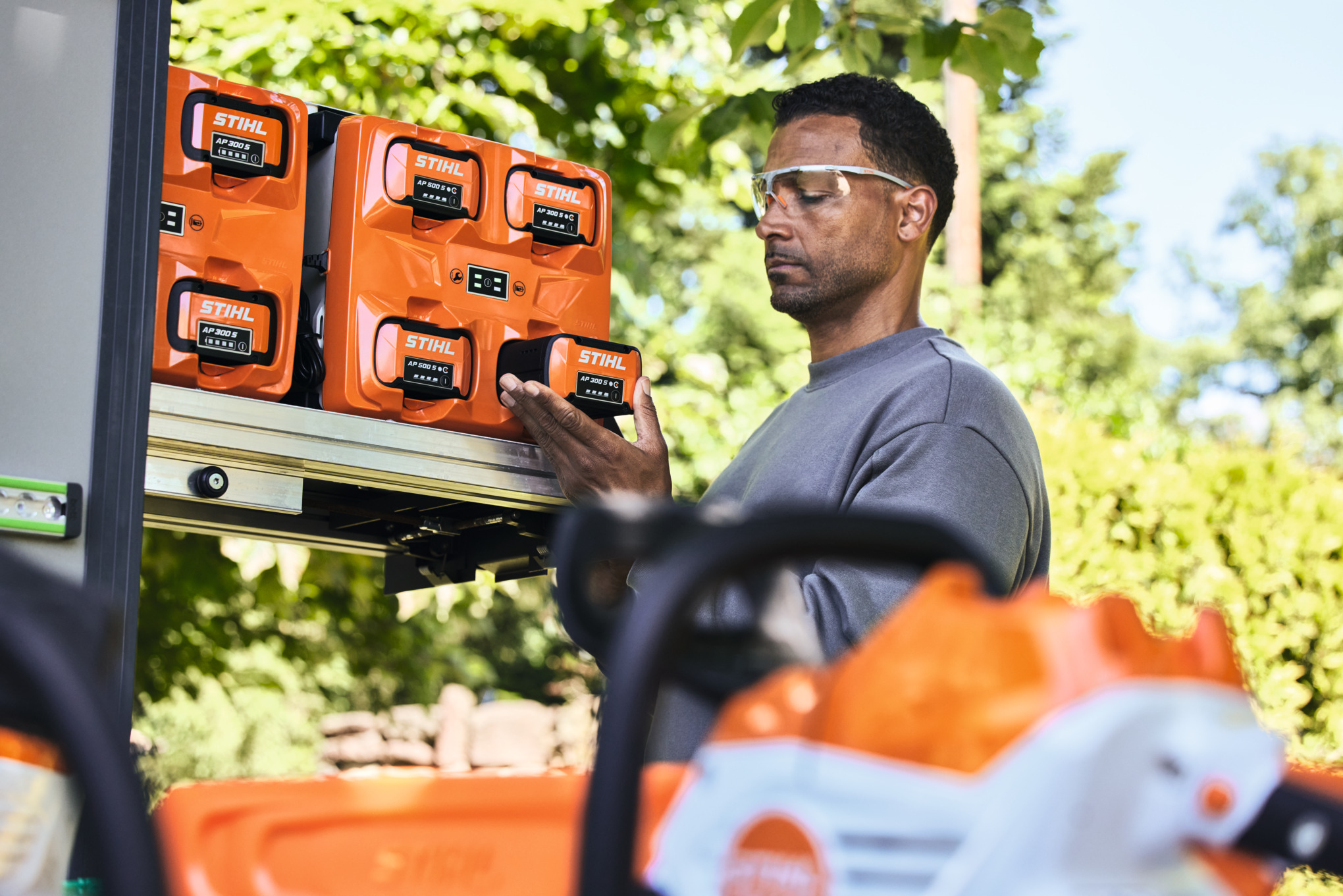 Un hombre con gafas de seguridad con la batería STIHL AP 300 S