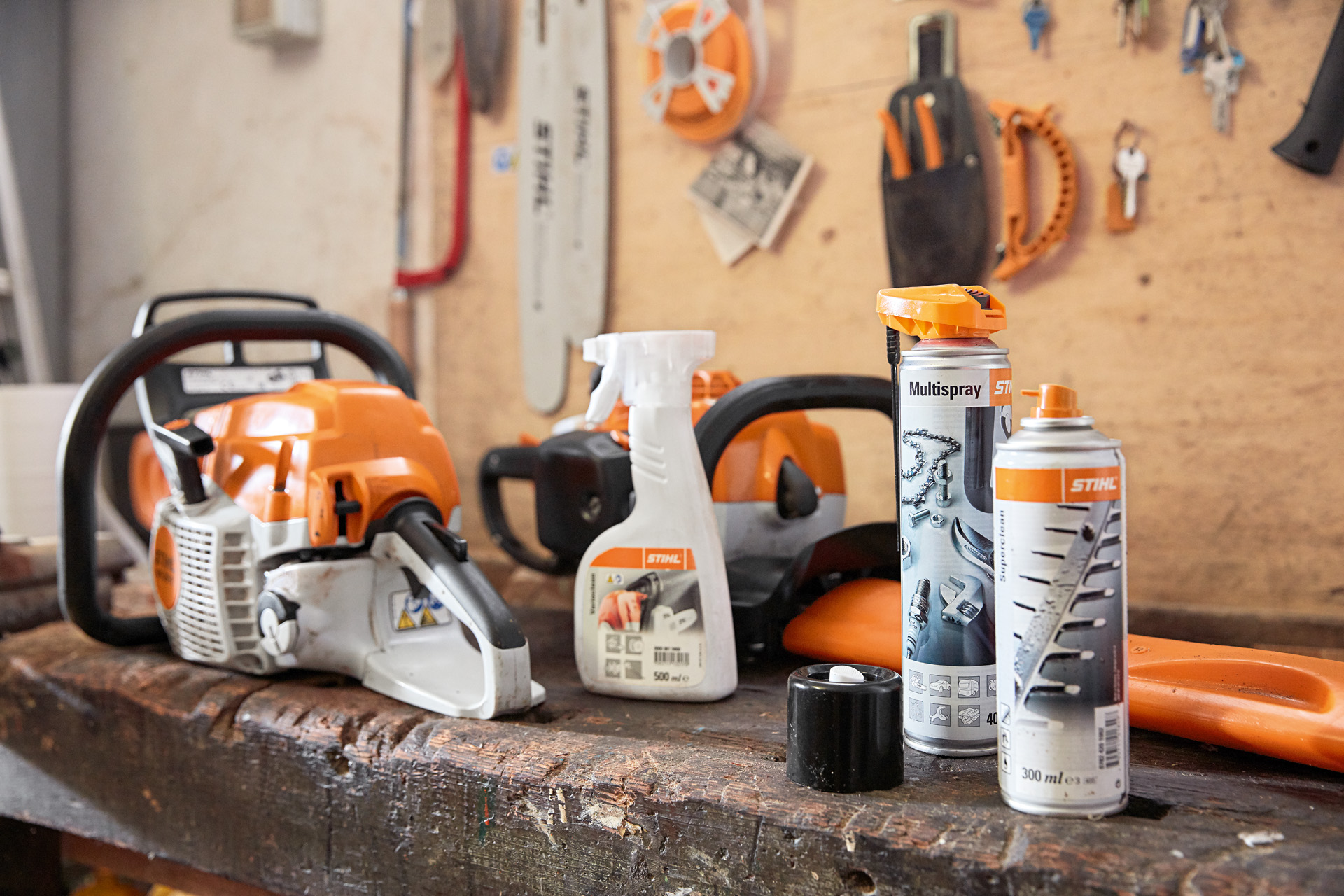 Un banco de trabajo con productos STIHL para la limpieza de la motosierra: Varioclean, Multispray y Superclean
