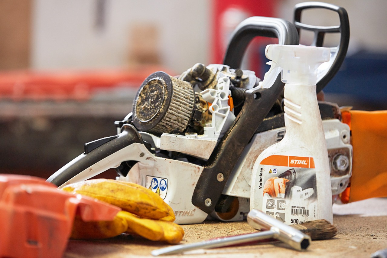 Una motosierra STIHL en un banco con el producto para mantenimiento de motosierras STIHL Varioclean 